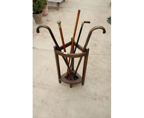 AN OAK CORNER STICK STAND WITH 5 VARIOUS WALKING STICKS 