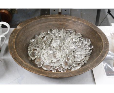 A QUANTITY OF CHANDELIER PRISMS, DROPPERS, BEADS AND CLIPS IN A VINTAGE WOODEN BOWL, DIAMETER 42CM 
