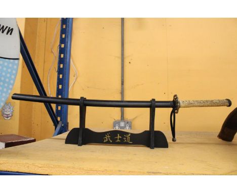 A VINTAGE SAMURAI SWORD ON A STAND 