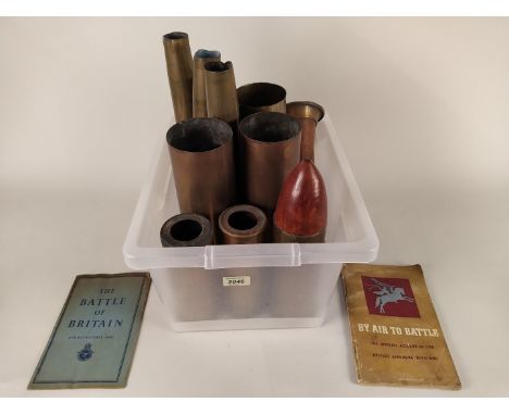 A collection of ten brass shell cases (WWII dated and later) with a copper and brass bugle and two booklets