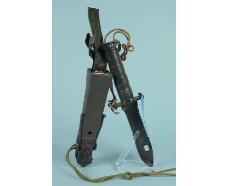 A modern survival knife with sawback blade and compass within grip etc