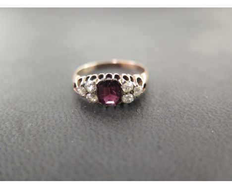 A garnet and diamond dress ring - The octagonal garnet to the old-cut diamond trefoils - Estimated total diamond weight 0.40c