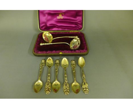 A set of six German 800 silver teaspoons with pierced floral decoration to tops, a small ladle and straining ladle with gradu