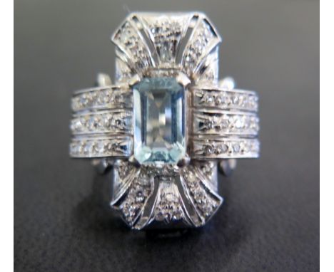 A Deco style aquamarine and diamond cluster ring - The rectangular-shape aquamarine within an eight-cut diamond surround to t