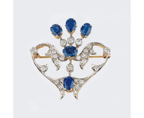 Florale Saphir-Brillant-Brosche. Um 1930. 14 kt. GG mit WG. Floral geschwungene Stege mit 28 Diam. im Brillant-, Übergangs- u