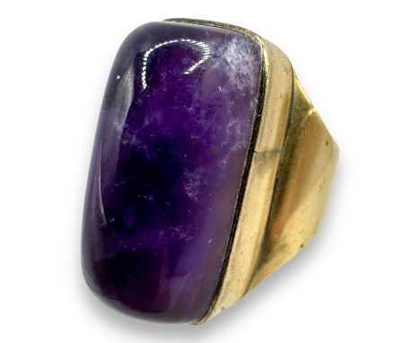 A modernist Amethyst tumble stone set cocktail ring. Featuring a precious yellow metal mount, stamped "9ct" and testing accor