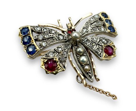 A diamond, sapphire, ruby and seed pearl butterfly brooch, set into silver and gold.  Set with six round mixed cut sapphires,