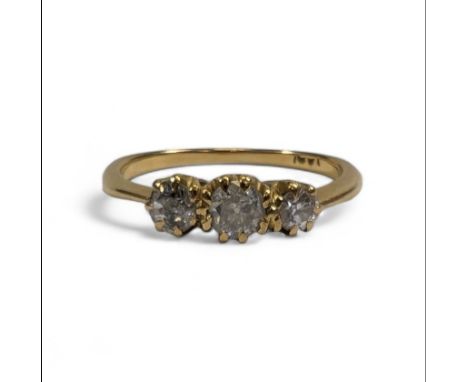 A diamond trilogy ring, set with a heavily included central old mine cut diamond, and&nbsp; a further old cut diamond and a r