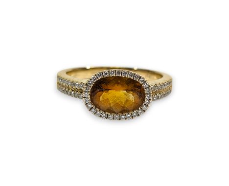 A citrine and diamond set dress ring. Set with a central oval chequerboard cut citrine, measuring approximately 9.8mm x 6.9mm
