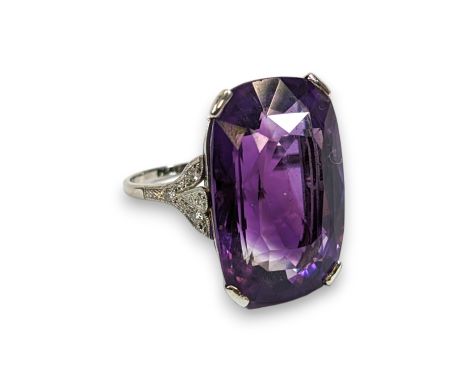 An Art Deco style amethyst and diamond cocktail ring. The amethyst measures approximately 23.5mm by 15.5mm by 11.5mm. Set in 