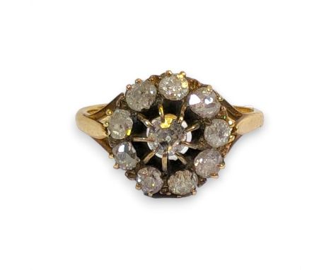 An old mine cut diamond set cluster ring.  Featuring a raised Belcher set diamond to the centre, approximately 3.8mm in diame