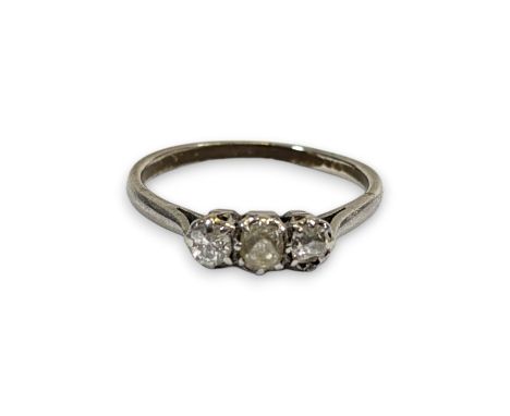 A diamond trilogy ring. Set into greyish white precious metal with three old mine cut diamonds. The central stone measuring a
