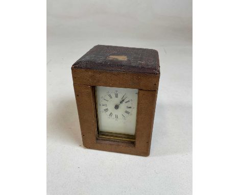 A circa 1900 French brass cased carriage clock with Roman numerals to the white enamel dial and in travelling case with key, 