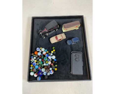 A small group of vintage model vehicles and a bag of marbles.