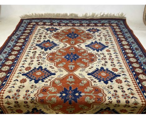 A Turkish Sumak rug with four elephant foot medallions to the central cream ground within a step stylised border, 169cm x 245