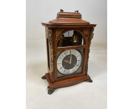 A contemporary French mantel clock with Roman numerals to the silvered chapter ring and with figure striking a bell to a visi