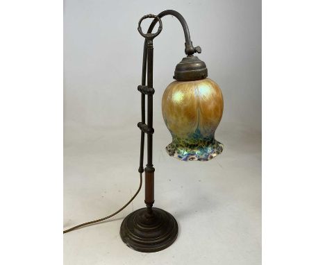 An Art Nouveau brass mounted adjustable table lamp with iridescent tinted glass shade. 