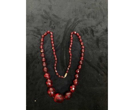 A vintage facet cut cherry amber coloured graduated necklace, length 68cm, approx 52g.