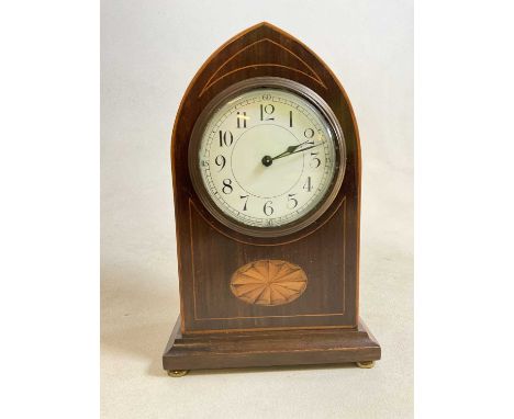 An Edwardian mahogany and inlaid lancet topped mantel timepiece with Arabic numerals to the white enamel dial and raised on f