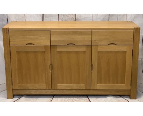 ULTRA-MODERN LIGHT OAK SIDEBOARD on substantial corner block supports, having three frieze drawers and three lower cupboard d