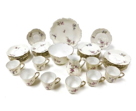 An early 20thC Limoges porcelain tea service, decorated with floral sprays, gilt heightened against a cream ground, comprisin