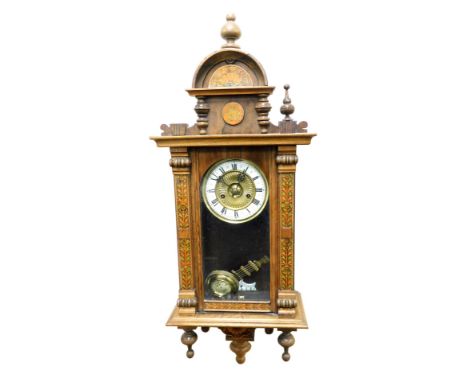 A late 19thC beech cased Vienna wall clock, with painted floral detailing, circular brass dial with enamel chapter ring beari