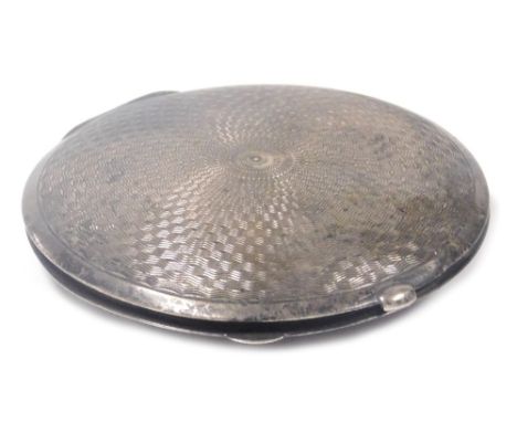 A George VI silver powder compact, of circular form with engine turned decoration and engraved crest, the interior with mirro