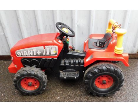A Giant + III red electric child's ride on tractor. 