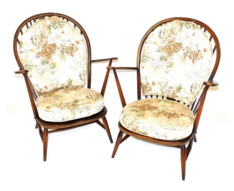 A pair of Ercol dark elm and beech Windsor back armchairs, with open arms and floral decorated loose cushions, 73cm wide.  Th