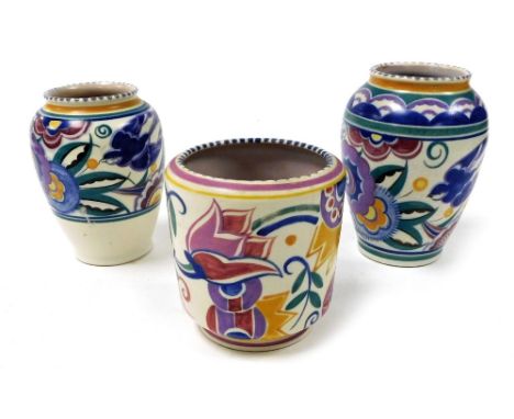 Three mid century Poole pottery vases, two painted with swallows and flowers, 16cm and 15cm high, the third with stylised flo