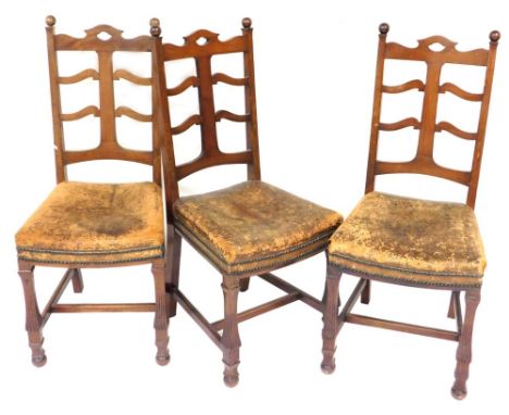 A set of three Edwardian mahogany dining chairs, each with part ladder back, a brown leather seat, on reeded square section l