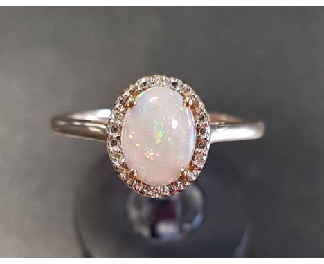 OPAL AND DIAMOND CLUSTER RINGthe central oval opal in diamond surround, on nine carat gold shank, ring size N 