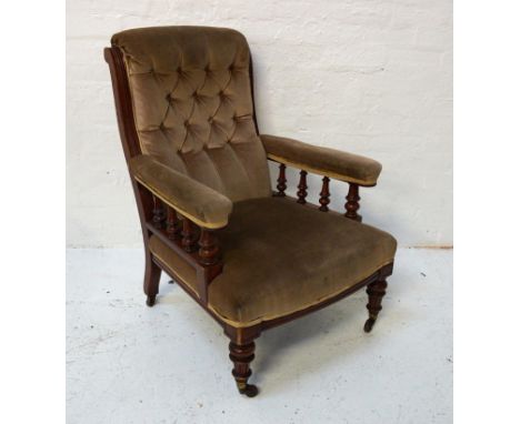 VICTORIAN ARMCHAIRwith a mahogany frame and a button back above padded arms with turned supports below and a stuffover seat, 