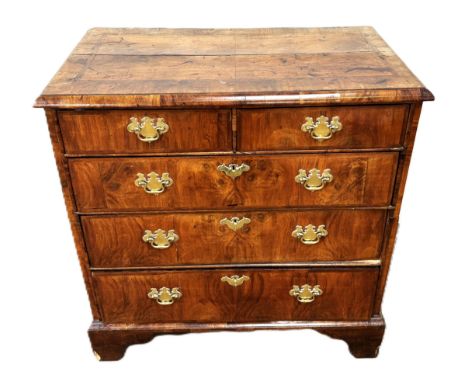 An attractive George I walnut chest of drawers, circa 1710,  with a feather banded and cross banded quarter veneered top, ove
