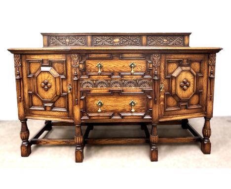 A Tudor style oak sideboard, finely carved with panelled doors on supports united by arrangement of stretchers, 120 x 185 x 7