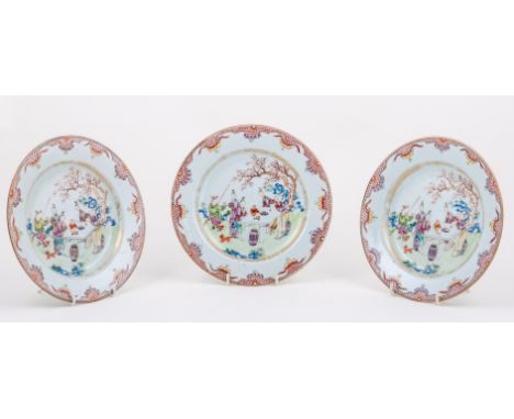 Three Chinese export porcelain plates, Quinlong, each painted with figures at the table in a garden setting, painted in polyc