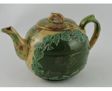 A late 19th century Dunmore Whieldon teapot, of dribbled  green and brown glaze, the body incorporating an ivy border cartouc