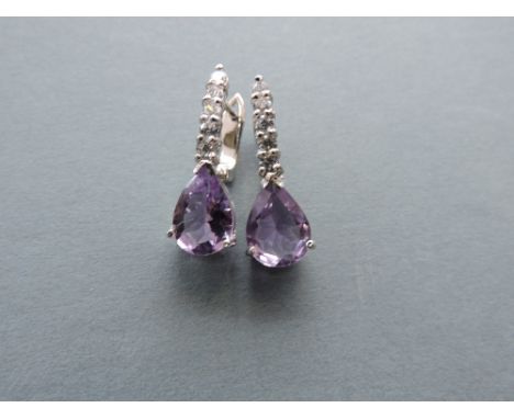 A pair of amethyst and white metal mounted ear clips.