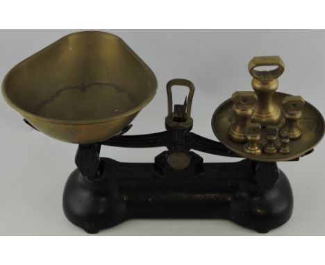 A pair of 20th century cast metal balance scales with brass pans and six graduated turned weights; together with a table lamp