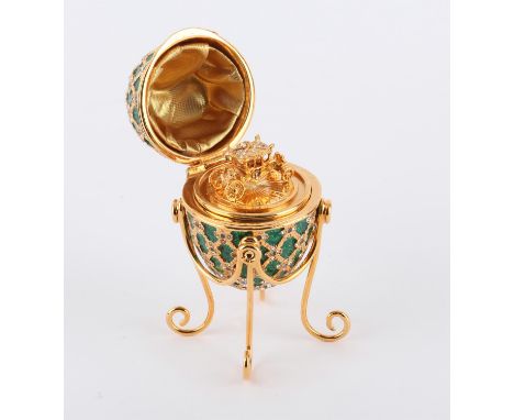 A replica limited edition Faberge egg, the 22 carat gold plated body encrusted with 96 pale sapphire coloured Swarovski cryst