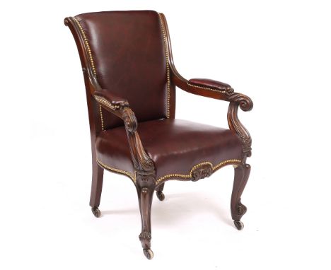 AN OXBLOOD RED LEATHER UPHOLSTERED LIBRARY ARMCHAIR with scrolling arms, cabriole legs and ceramic casters, 71cm wide x 64cm 