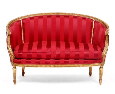 A LOUIS XVI STYLE GILT FRAMED SMALL SOFA with curving back, scroll terminals to the arms and standing on fluted turned taperi