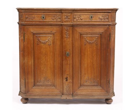 A LATE 18TH CENTURY FLEMISH OAK SIDE CABINET with carved decoration to the two frieze drawers above panelled cupboard doors, 