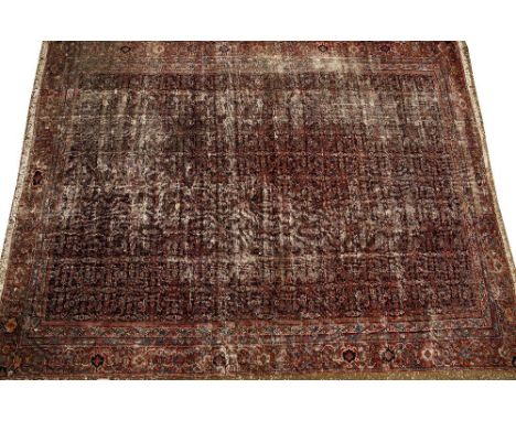 AN ANTIQUE PERSIAN RED GROUND SMALL CARPET with a banded border and all over geometric decoration, 305cm x 405cm