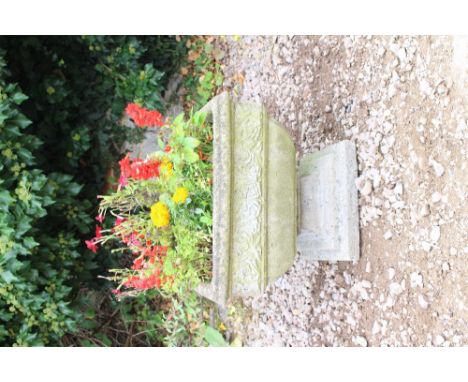 A SQUARE RECONSTITUTED STONE PLANTER  with a rose flower decorated banded border and a stepped square base 51.2cm wide x 44cm