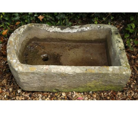 AN ANTIQUE STONE TROUGH with rounded end, 70cm long x 50cm wide x 24cm high