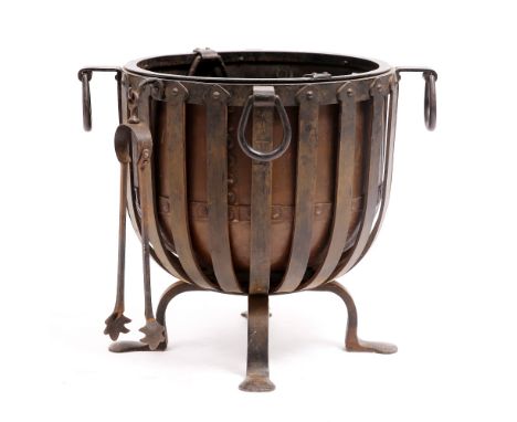 AN EARLY 20TH CENTURY BLACKSMITH MADE WROUGHT IRON COAL BUCKET of cresset form with copper liner and ring handles and standin