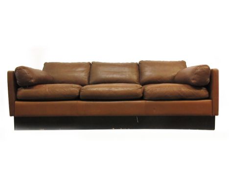 A 1970's brown three seater sofa on a black plinth base