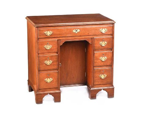 ANTIQUE MAHOGANY KNEEHOLE DESK FITTED WITH SIX SMALL DRAWERS AND ONE LONG DRAWER WITH BRASS DROP HANDLES.RAISED ON BRACKET FE