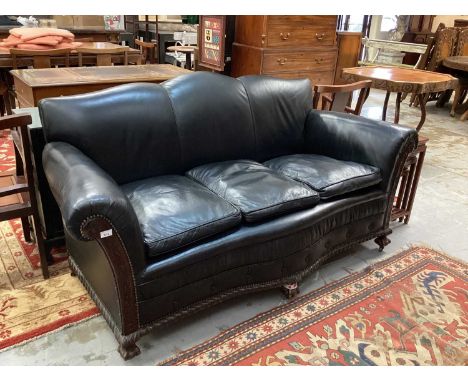 Edwardian black leather upholstered sofa and matching armchair with bowed mahogany frame on gadrooned frieze and claw and bal